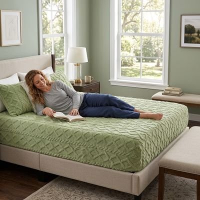 Drap housse femme allongée confortablement lit un livre